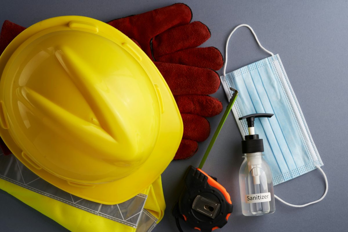 Construction workers in hi-vis vests and helmets working in bright desert sunlight